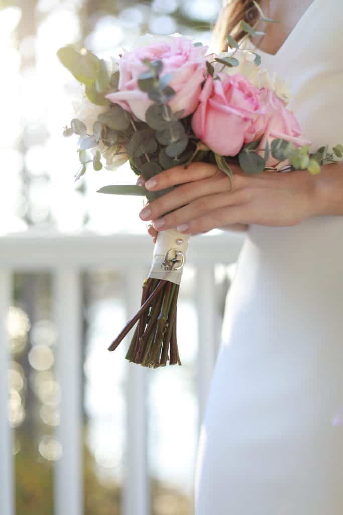 Bride holding her bouquet on the porch of her wedding