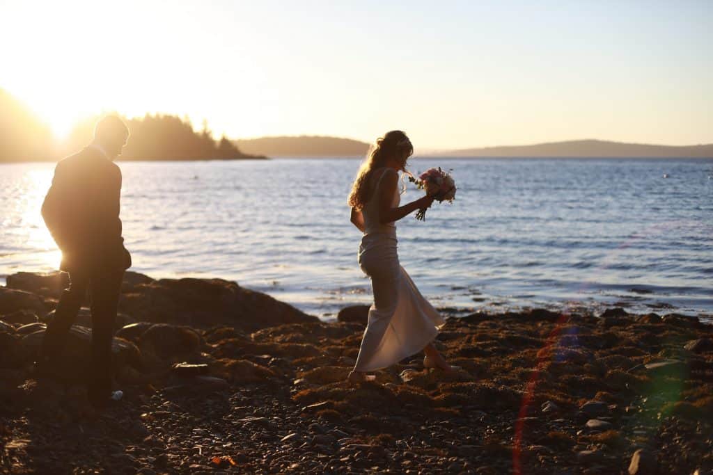 bride and groom walking on the beach, sunset, blue ocean
