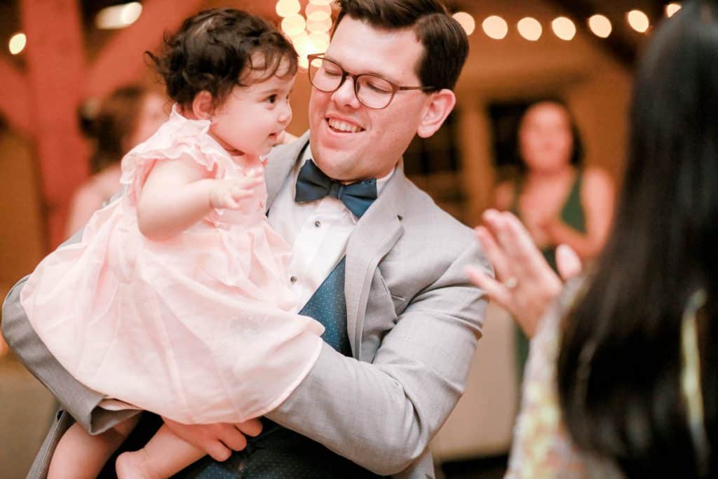 groomsman with dancing with his infanct daughter