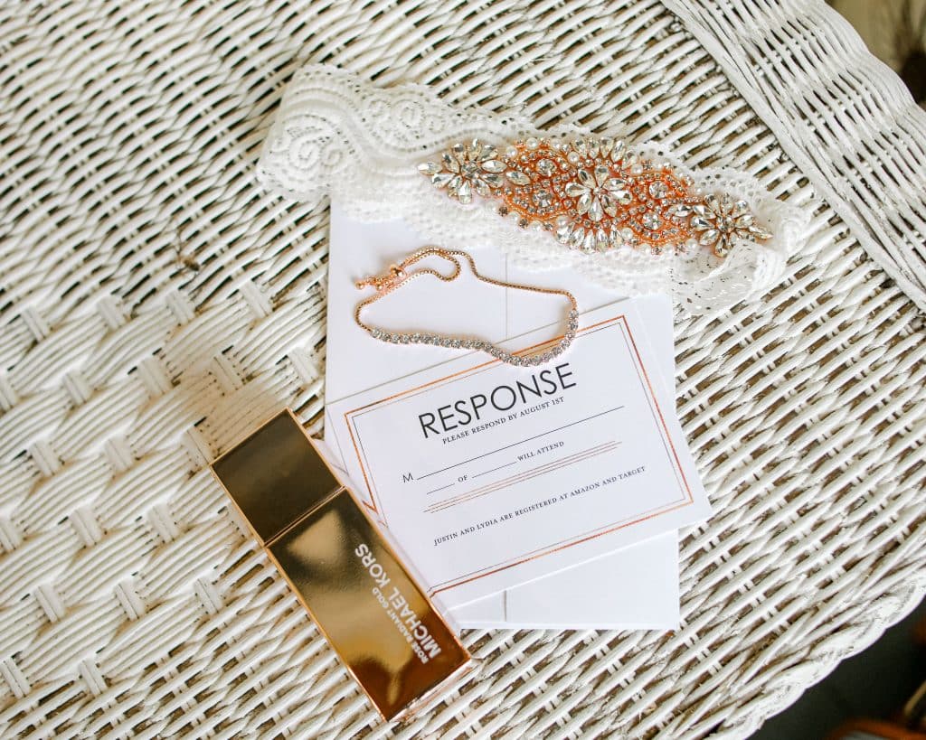 Wedding details. wedding glowers, jewlery, invitations and perfum on a chair on the patio