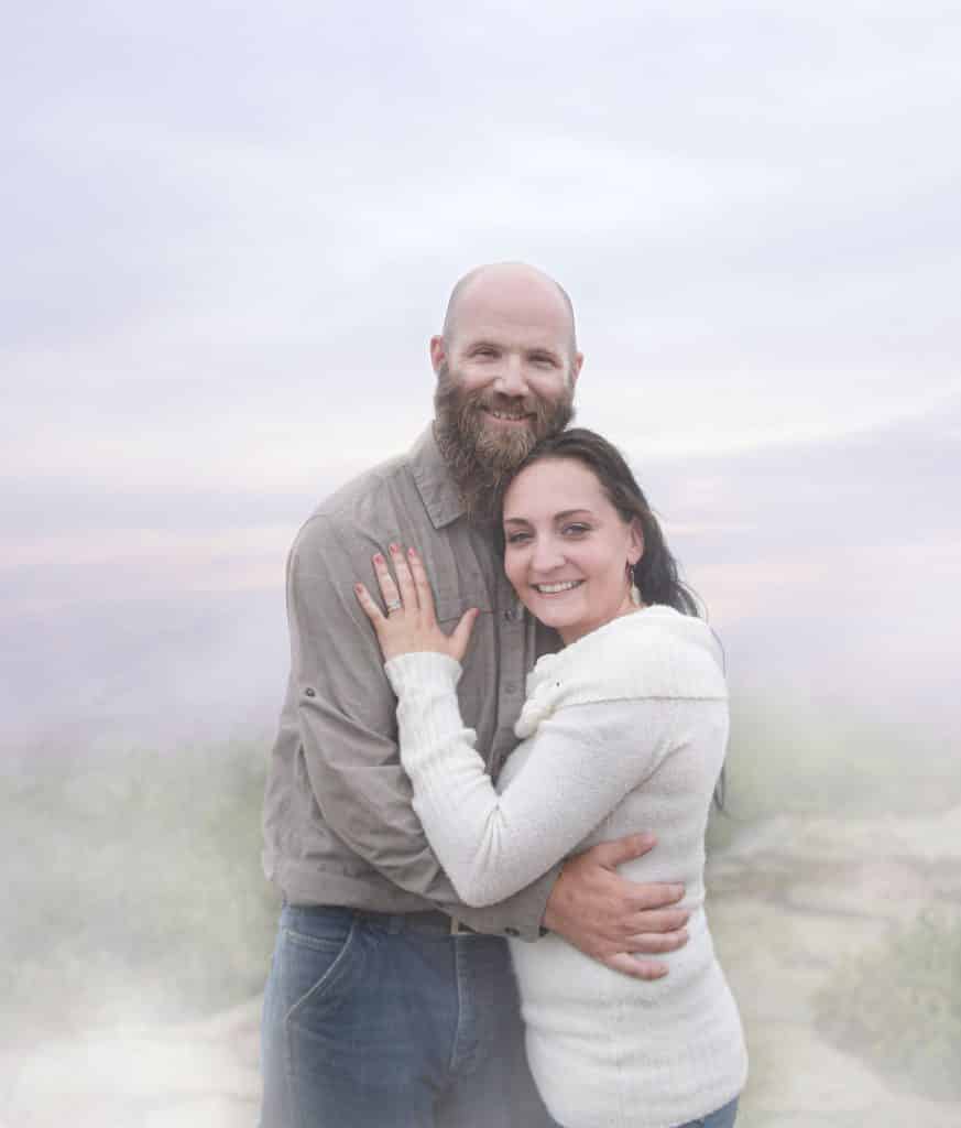 newly engaged couple hugging on top of cadillac mountain, foggy
