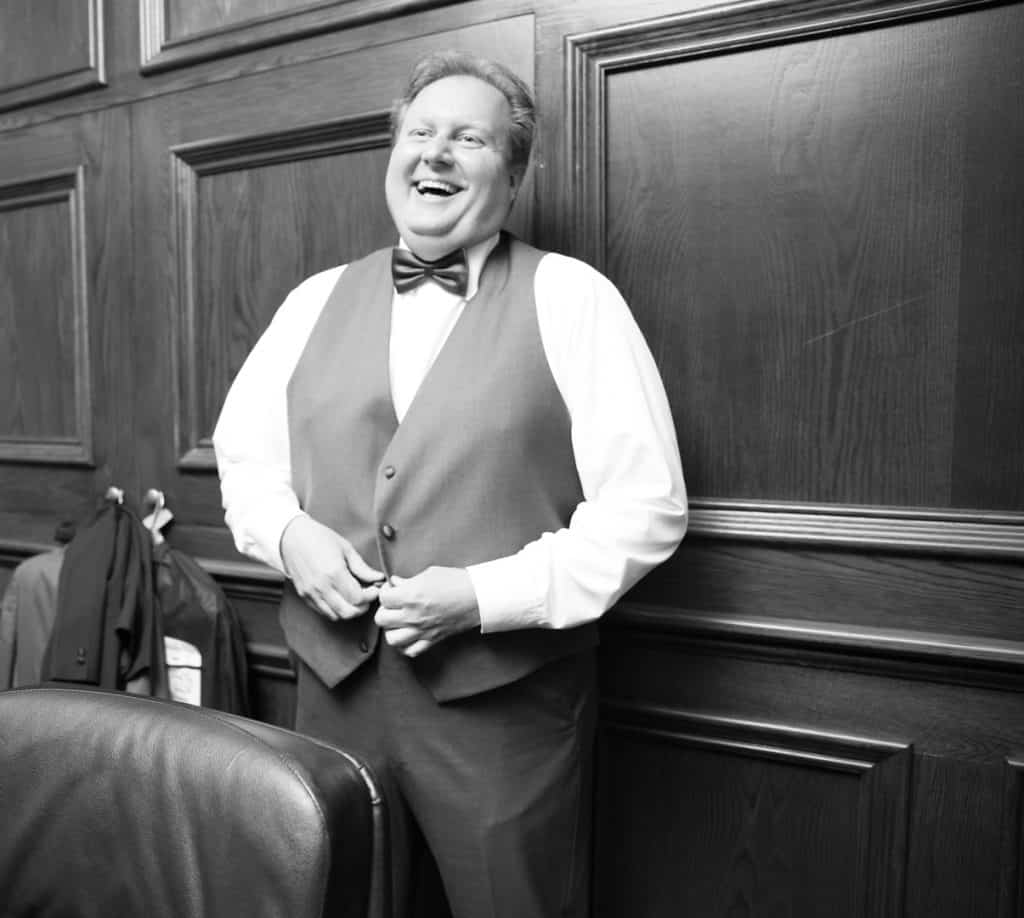 Groom laughing as he prepares for his wedding