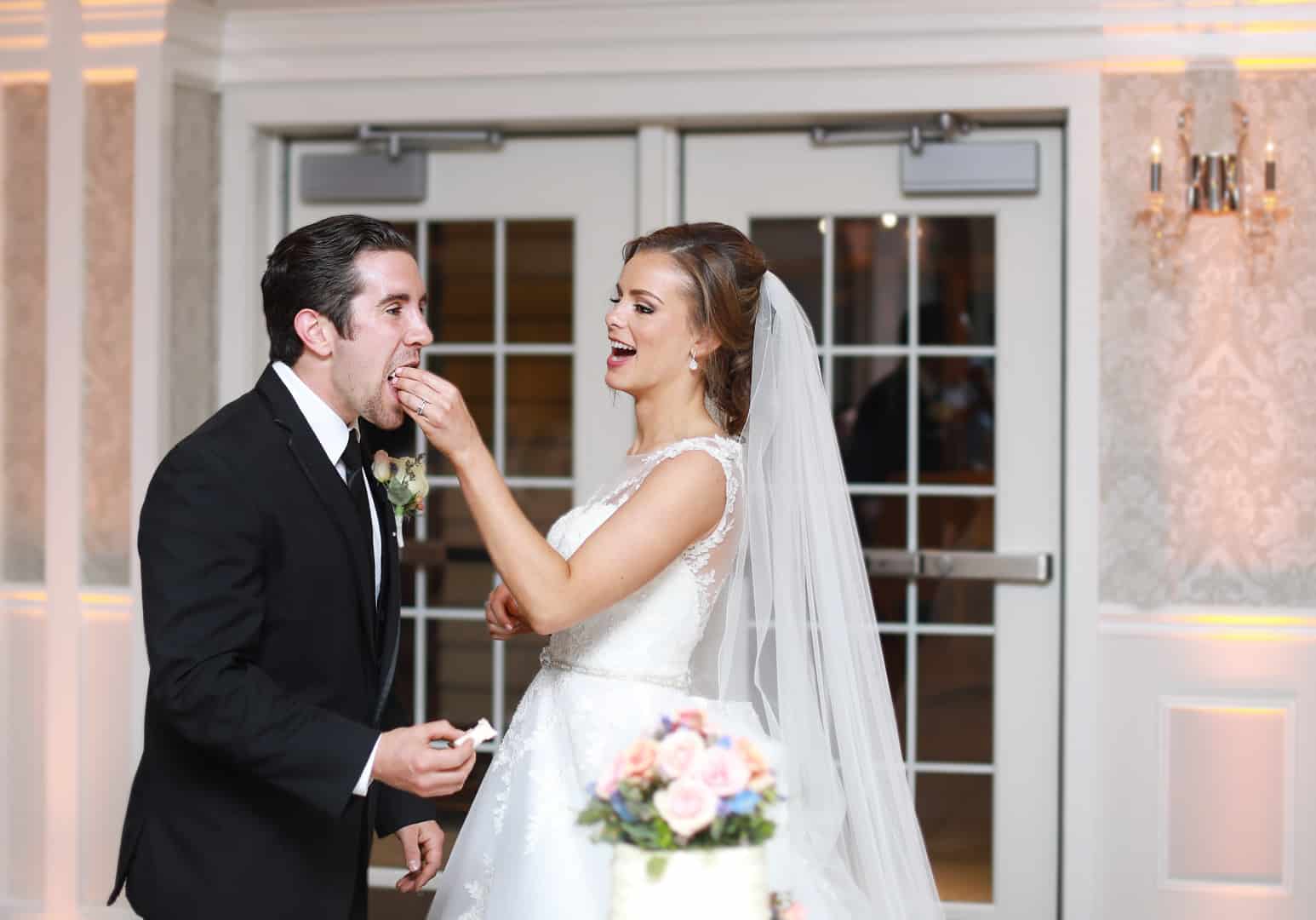 bride feeding the groom cake at reception