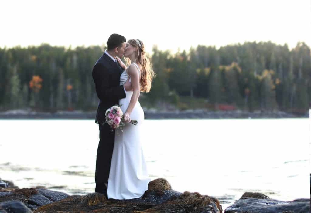 bride and groom getting married in Bar Harbor Maine on the ocean, kissing