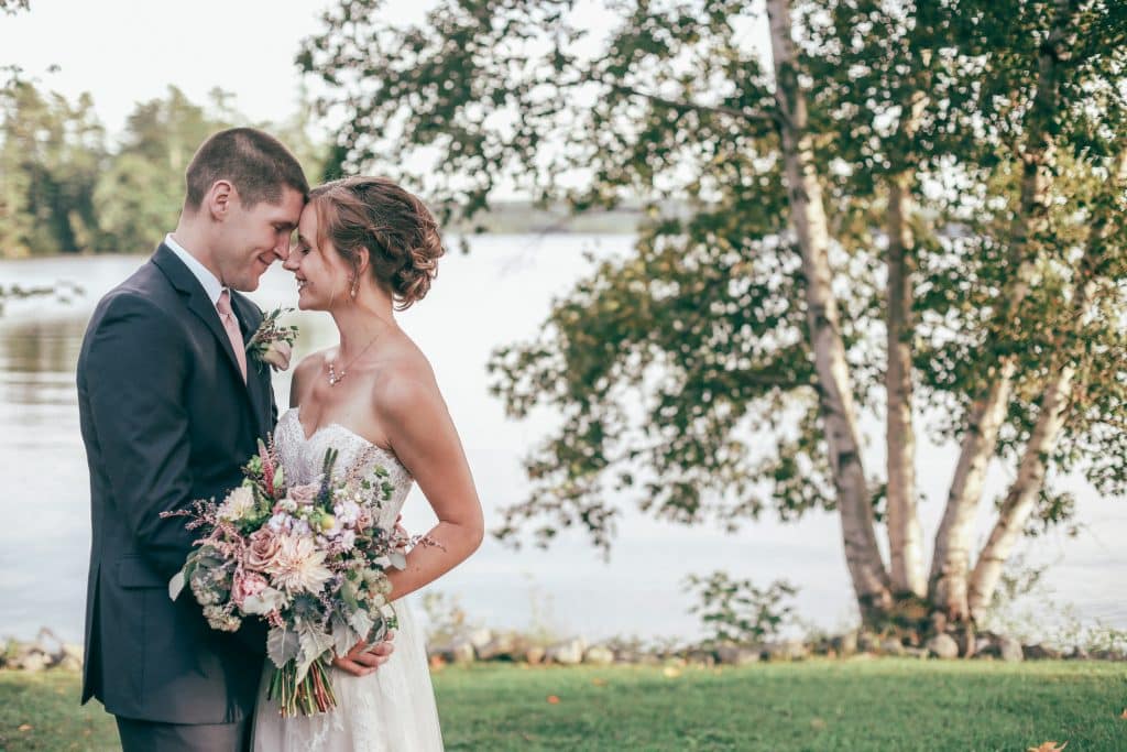 bride and groom gazing into each others eyes near the lake