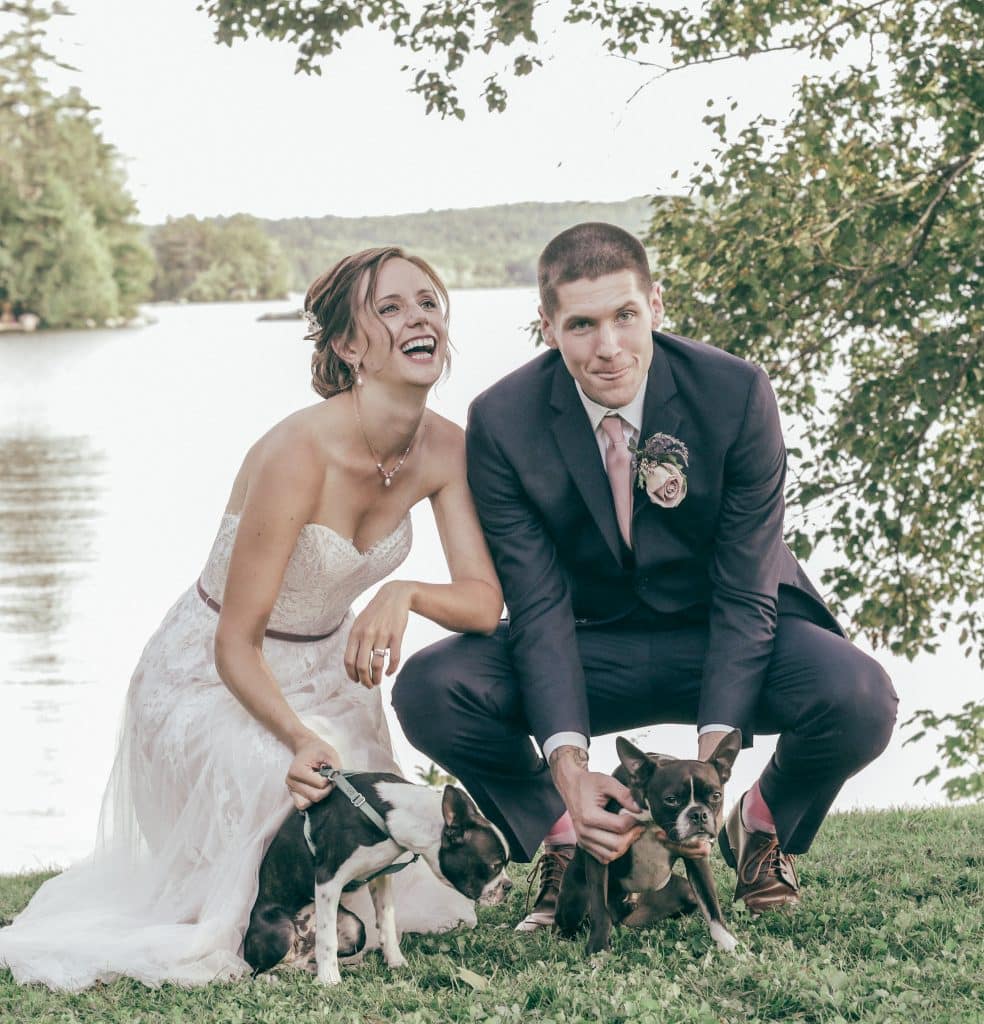 bride and groom with their puppies laughing