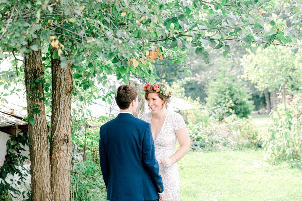 bride and groom first look, bride smiling at her groom under a willow tree