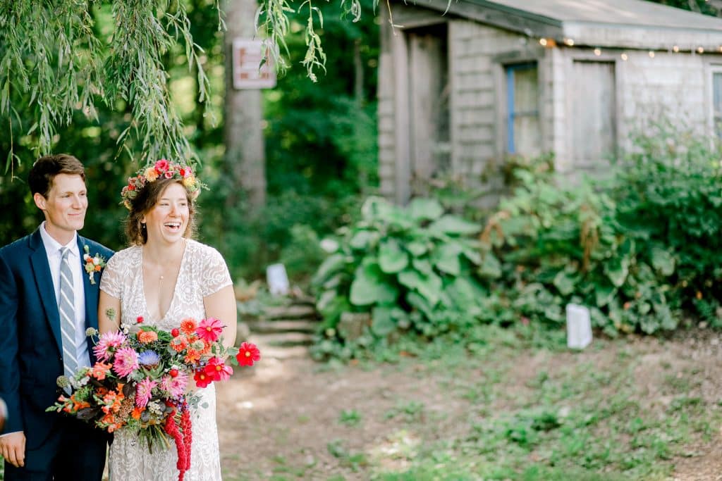 candid moment of bride and groom together looking off into the distance with the green bath and small barn in the background