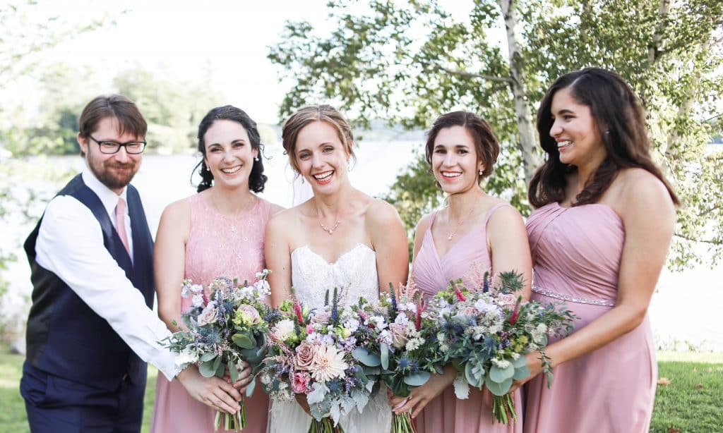 bridal party girls and guy looking at the camera