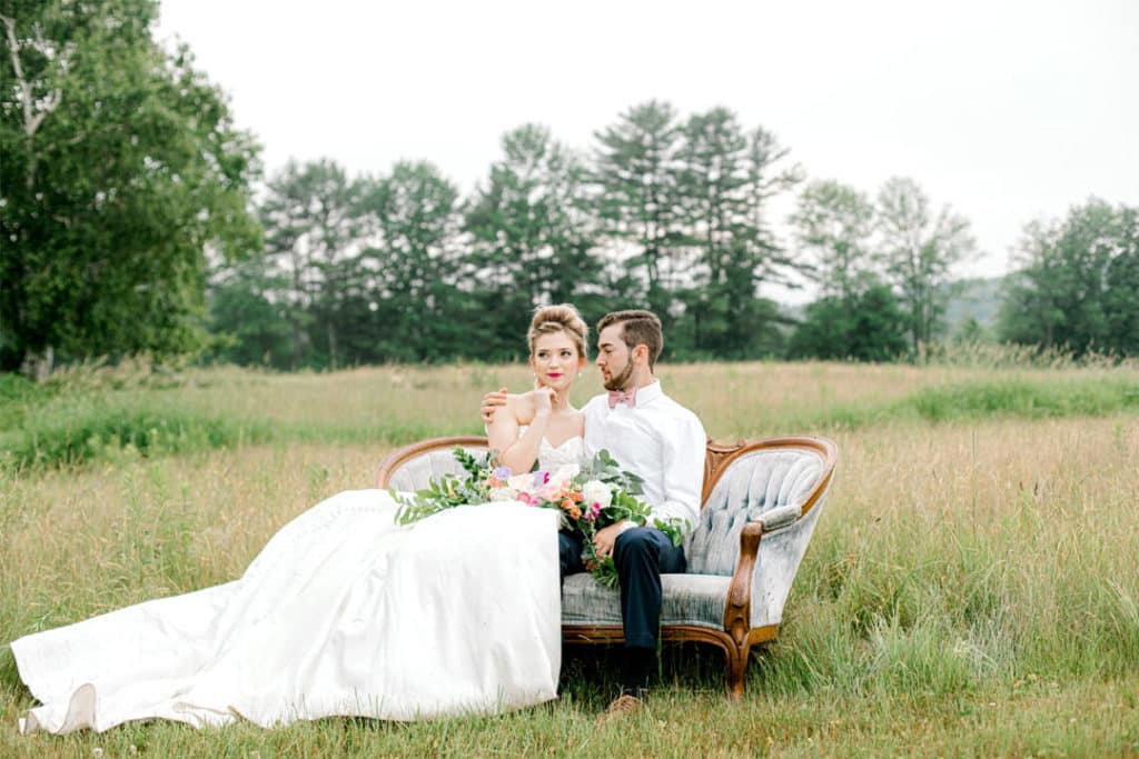 bride and groom on a couch for a photography session in maine