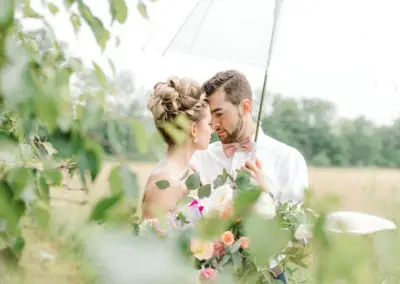 bride and groom under clear umbrella