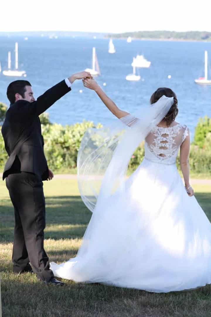 bride and groom on Portland Maine ocean with sailboats in background