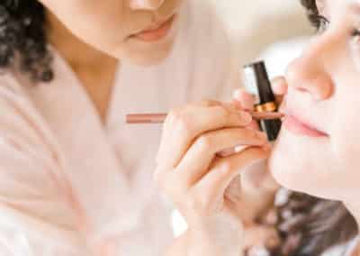 putting lipstick on before a maine wedding