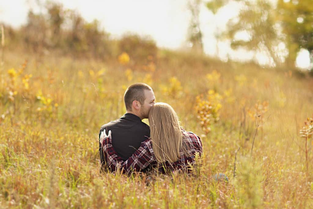 engaged maine couple in a field