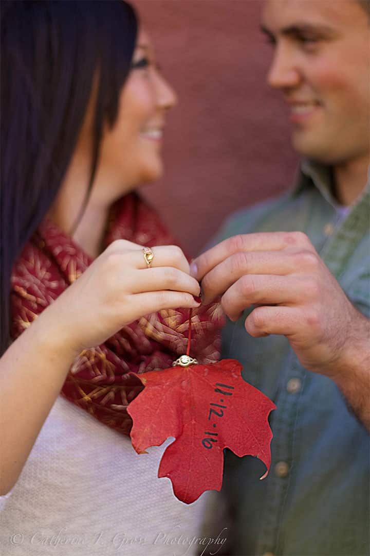 Maine engagement photo of couple holding a leaf