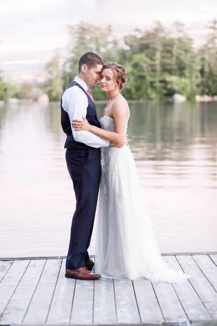 Braide and groom taking photo on lake near Bangor Maine