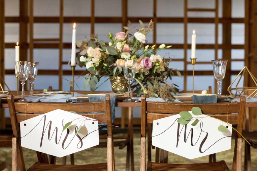 wedding party head table with chairs labeled "Mr." and "Mrs."