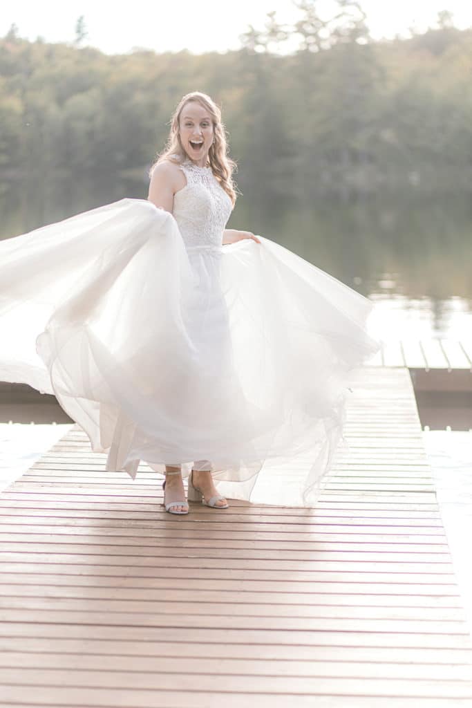 bride twirling dress on a dock on a maine lake