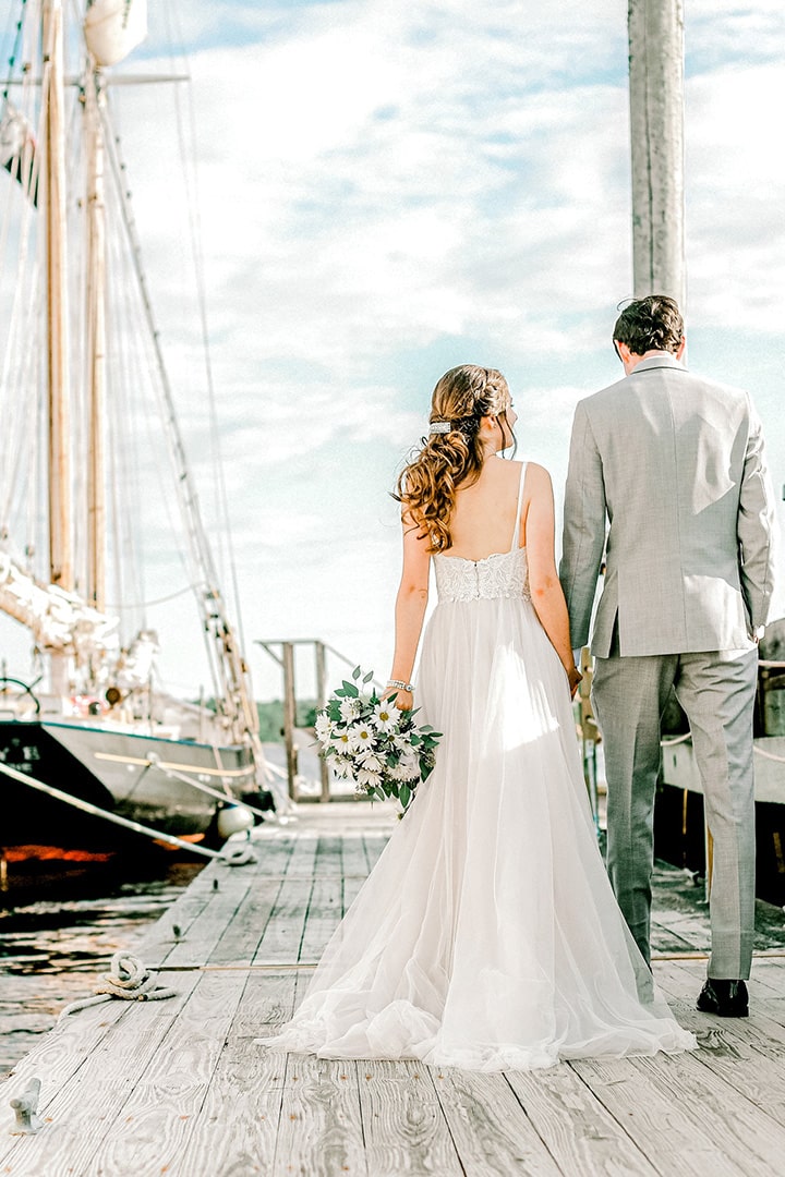 elopement photographer: catherine j. gross captures couple walking next to sailboat