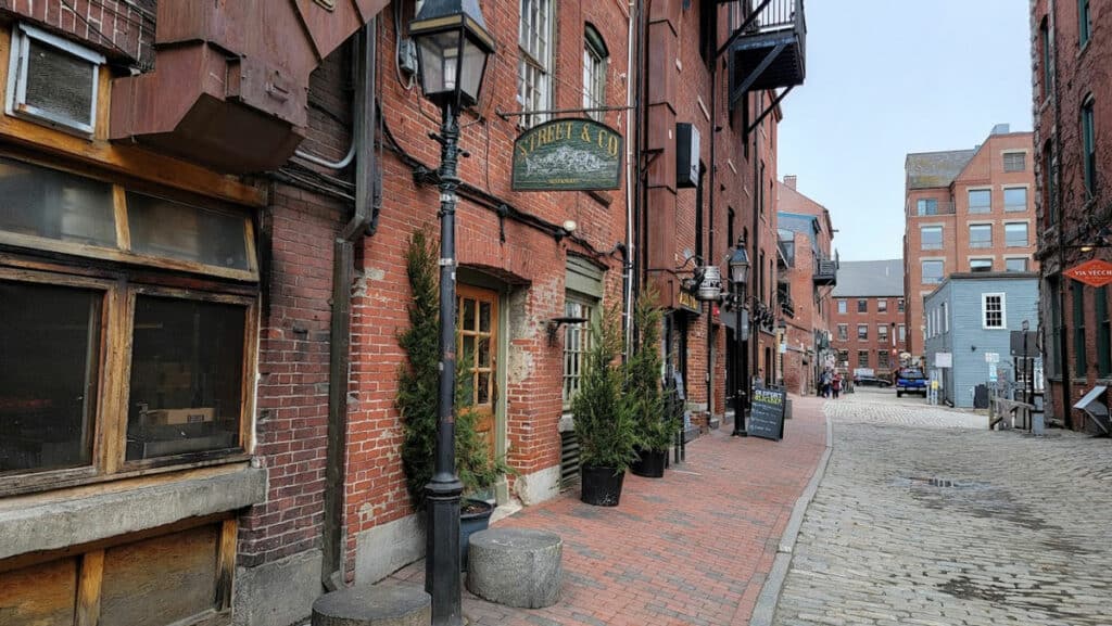 Outside of Street & Company in Portland Maine - red bricked building with a green sign above the door.