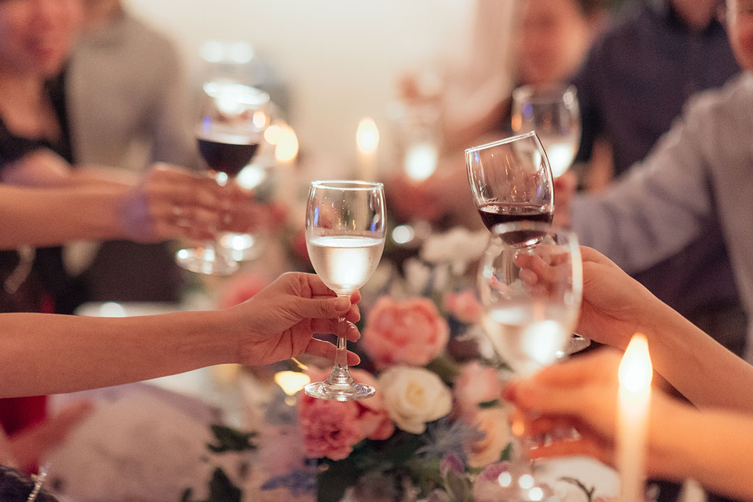 a wedding rehearsal dinner in portland maine, many people clinking glasses after a toast