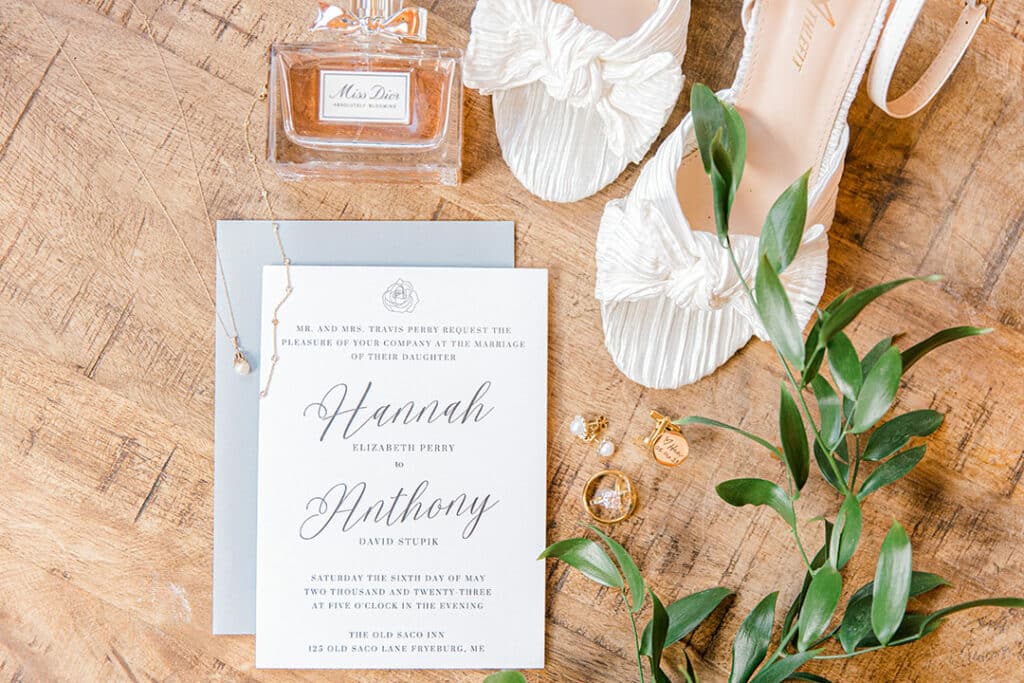 detailed wedding shots of invitations, wedding rings, brides shoes and perfume bottle