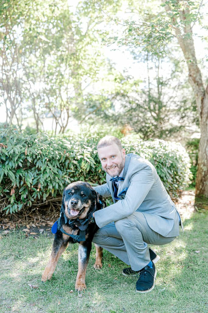 groom posing with his dog at a spruce point inn wedding.