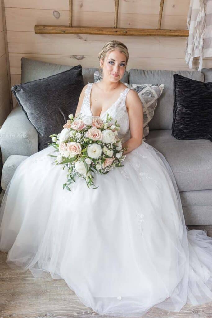 Bride sitting gracefully with her bouquet before the ceremony